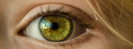 Das Auge einer Frau mit grüner Iris.
